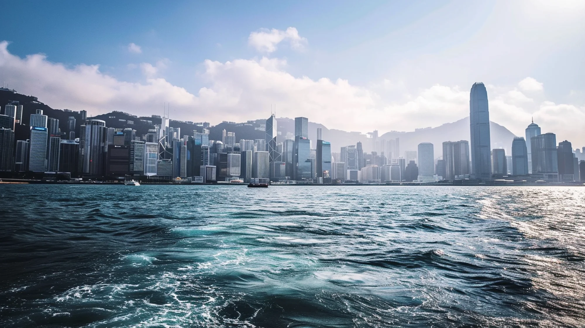 Metropolis with water in the foreground and mountains behind the city